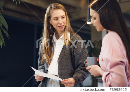 Two young women working together in office Two young women working together in office 78992625