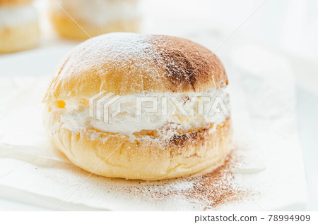 Maritozzo with plenty of cream with powdered sugar Maritozzo with plenty of cream with powdered sugar 78994909