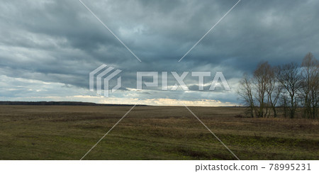 Dramatic sky over the autumn field. Evening landscape. 78995231