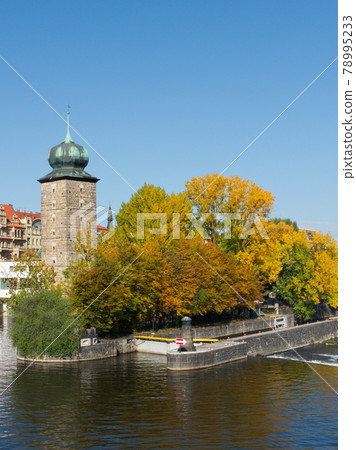 Ancient tower on the river bank in the fall. Autumn Prague. Landscape. 78995233