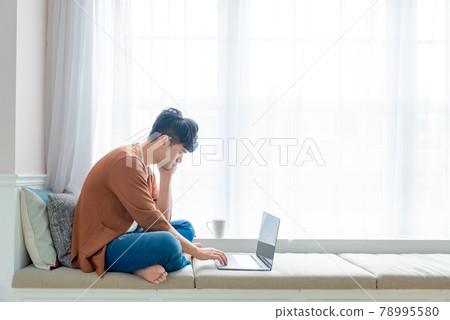 年輕男子在家使用電腦工作 年輕男子在家使用電腦工作 78995580