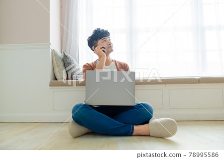 Young man working on computer at home Young man working on computer at home 78995586