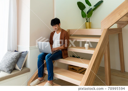 Young man working on computer at home Young man working on computer at home 78995594