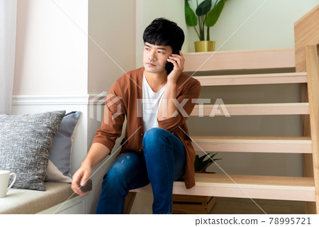 年輕男子在家工作中間休息喝咖啡打電話 年輕男子在家工作中間休息喝咖啡打電話 78995721