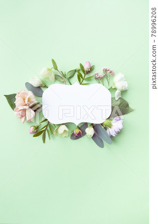 Floral frame with pink roses, white flowers, branches, leaves and petals on green background. Flat lay, top view 78996208