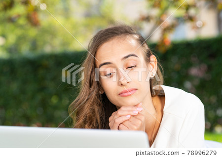 young woman and laptop in the park 78996279