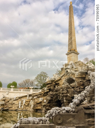 high obelisk in Egyptian style, high Egyptian-style obelisk, many sculptures, cloudy sky, masonry 78996965