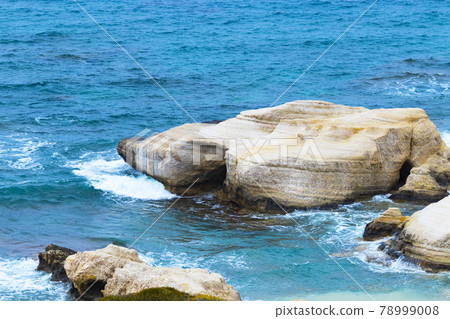 Ocean waves splash against beach with rocks background, Cliffs in the sea, Top aerial view of Cyprus, Nature Background with Ocean, Vacation and relax in a secluded place Ocean waves splash against beach with rocks background, Cliffs in the sea, Top aerial view of Cyprus, Nature Background with Ocean, Vacation and relax in a secluded place 78999008