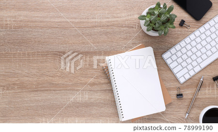 Top view wooden workspace office desk with computer and office supplies. Flat lay work table with blank notebook, keyboard, green leaf, pen and coffee cup. Copy space for your advertising content. Top view wooden workspace office desk with computer and office supplies. Flat lay work table with blank notebook, keyboard, green leaf, pen and coffee cup. Copy space for your advertising content. 78999190