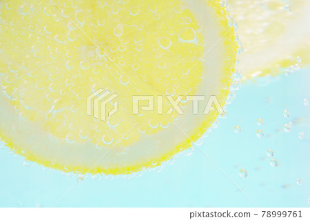 Light blue background with lemon and carbonated water Light blue background with lemon and carbonated water 78999761