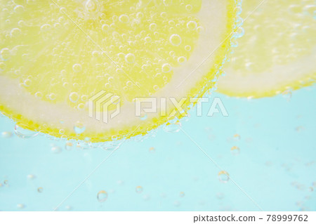 Light blue background with lemon and carbonated water 78999762