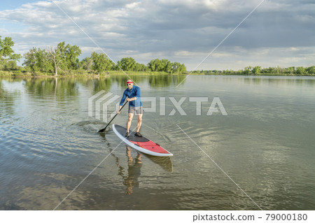 senior paddler on stand up paddleboard senior paddler on stand up paddleboard 79000180