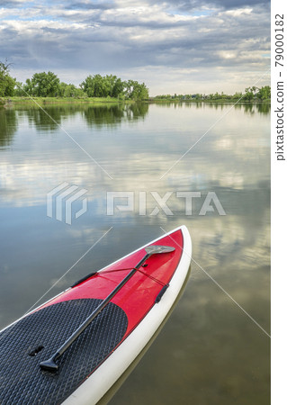 stand up paddleboard on calm lake stand up paddleboard on calm lake 79000182