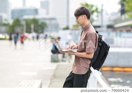 A man standing and looking at a computer 79000424