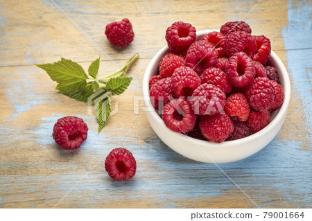 fresh red raspberries with green leaf fresh red raspberries with green leaf 79001664