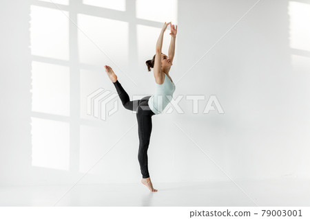 Woman practising rhythmic gymnastics alone Woman practising rhythmic gymnastics alone 79003001