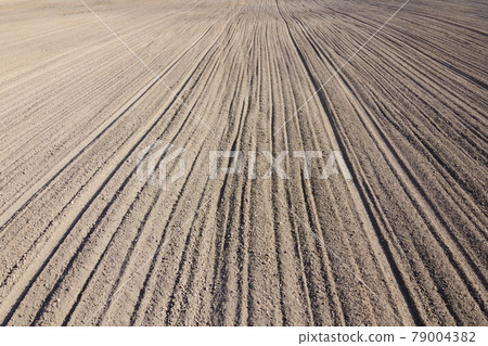 Plowed agricultural field, aerial view. Agricultural land. Background. Plowed agricultural field, aerial view. Agricultural land. Background. 79004382