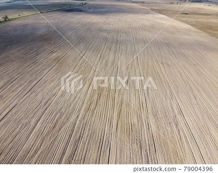 Plowed agricultural field, aerial view. Agricultural land. Plowed agricultural field, aerial view. Agricultural land. 79004396