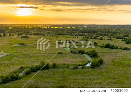 Aerial view of green grassland river valley Aerial view of green grassland river valley 79005693