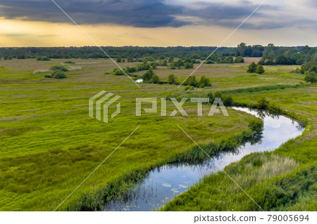 Aerial view of green grassland river valley Aerial view of green grassland river valley 79005694