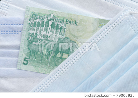 Qatar 5 riyals Banknote on surgical mask. Qatar 5 riyals Banknote on surgical mask. 79005923