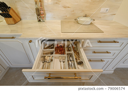 Drawer pulled out in cabinet at luxury beige and gold classic kitchen furniture Drawer pulled out in cabinet at luxury beige and gold classic kitchen furniture 79006574