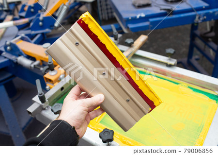 Squeegee for Serigraphy silk screen print process at clothes factory. Frame, squeegee and plastisol color paints Squeegee for Serigraphy silk screen print process at clothes factory. Frame, squeegee and plastisol color paints 79006856