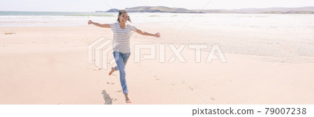 Happy freedom woman running carefree having fun with open arms on beach vacation travel. Summer sunshine holiday destination girl. Life happiness panoramic banner 79007238