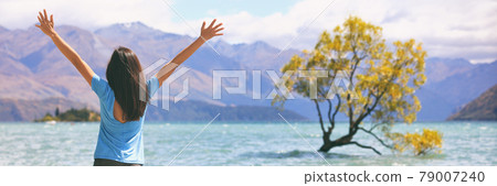 Happy wellness freedom woman in New Zealand winning with arms up in success at Wanaka Lone Tree, popular travel destination. Happiness in life concept. Panoramic banner of joyful girl Happy wellness freedom woman in New Zealand winning with arms up in success at Wanaka Lone Tree, popular travel destination. Happiness in life concept. Panoramic banner of joyful girl 79007240