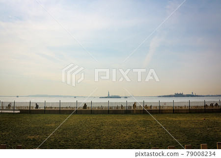 Statue of Liberty in the distance from Battery Park in New York Statue of Liberty in the distance from Battery Park in New York 79008234
