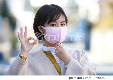 一個戴著口罩並用手打圈的女人 一個戴著口罩並用手打圈的女人 79008922