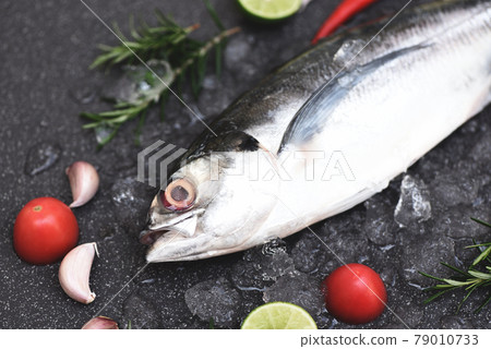 Fish on ice for cooking food in the restaurant, Fresh fish raw torpedo scad with lemon herb and spices, mackerel scad top view 79010733