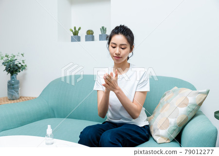 Girl disinfecting hands with alcohol 79012277