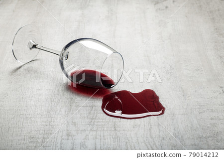 Wooden floor with overturned glass of red wine. Spilled wine on a wooden laminate parquet floor with moisture protection. Wooden floor with overturned glass of red wine. Spilled wine on a wooden laminate parquet floor with moisture protection. 79014212