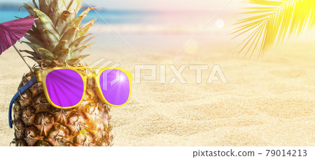 Summer tropical pineapple background. Pineapple in sunglasses under a palm tree on a beach background. Cocktail party on the beach, rest, relaxation and summer concept Summer tropical pineapple background. Pineapple in sunglasses under a palm tree on a beach background. Cocktail party on the beach, rest, relaxation and summer concept 79014213