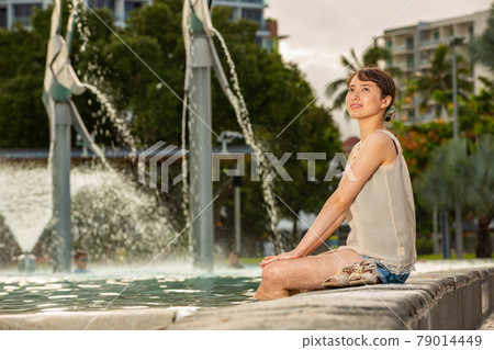 Half-beautiful woman sitting in the lagoon pool of Cairns Half-beautiful woman sitting in the lagoon pool of Cairns 79014449