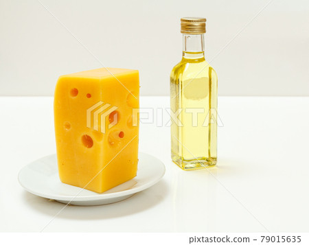 Cheese hit fitness on plate and sunflower oil on white background Cheese hit fitness on plate and sunflower oil on white background 79015635