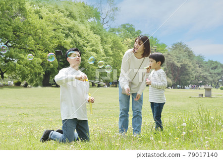 一家人在公園裡玩肥皂泡 一家人在公園裡玩肥皂泡 79017140