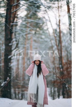 Young girl standing in the middle of snowy road. 79017406