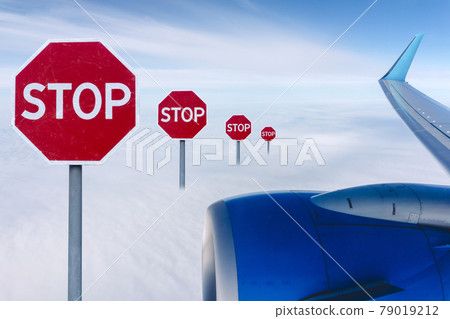 Flight ban and closed borders for tourists and travelers. No-fly zone concept. Airplane in flight with a STOP sign Flight ban and closed borders for tourists and travelers. No-fly zone concept. Airplane in flight with a STOP sign 79019212