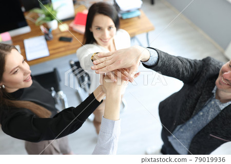 Young business people holding hands together demonstrating support and unity closeup Young business people holding hands together demonstrating support and unity closeup 79019936