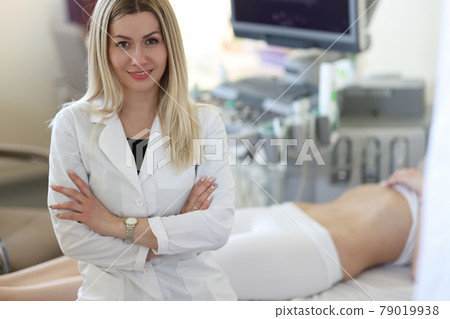 Portrait of young woman doctor sonographer in medical office with patient Portrait of young woman doctor sonographer in medical office with patient 79019938