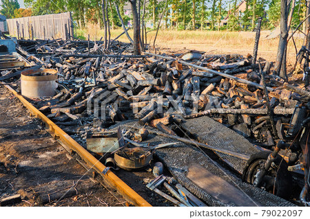 Fire ruin with fire debris from burnt wood, boards, walls and furnishings Fire ruin with fire debris from burnt wood, boards, walls and furnishings 79022097