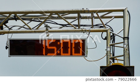 Large stopwatch with digital display showing the time in 15 seconds suspended from a galvanized steel tube frame. 79022666