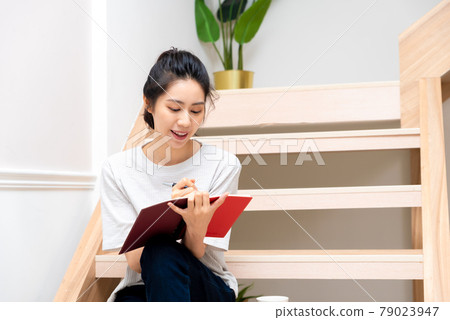 girl sitting on wooden stairs creating girl sitting on wooden stairs creating 79023947