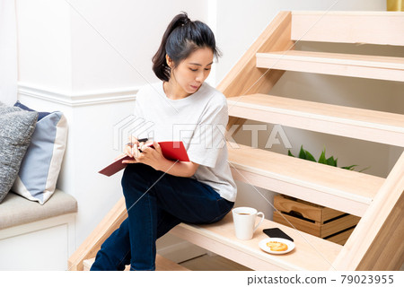 Girl sitting on wooden stairs enjoying dessert 79023955