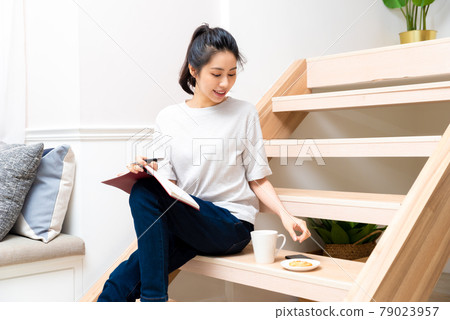 Girl sitting on wooden stairs enjoying dessert 79023957