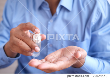 close up of young man hand using hand sanitizer spray. close up of young man hand using hand sanitizer spray. 79024540