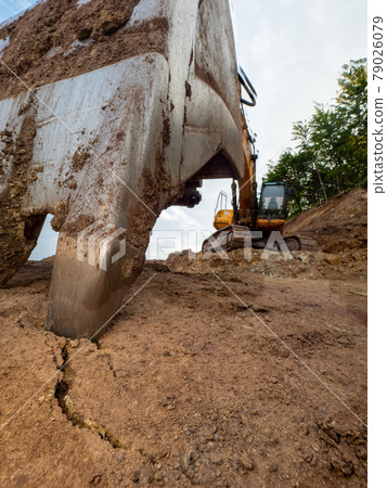 Industrial toothed digger bucket bite the ground. Industrial toothed digger bucket bite the ground. 79026079