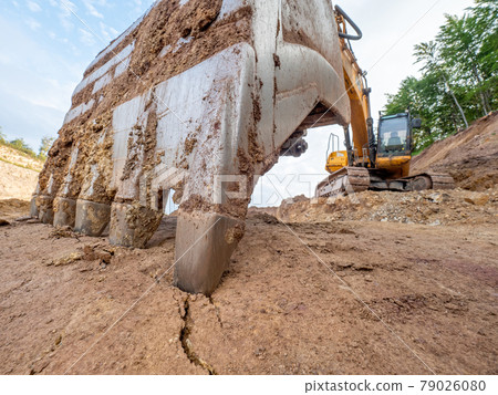 Detailed earth crack under bucket of heavy quarry loader in open mine Detailed earth crack under bucket of heavy quarry loader in open mine 79026080